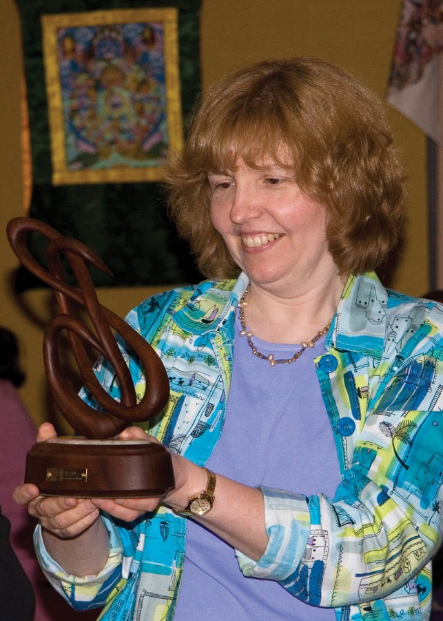 Carol Ourada receives a hand-carved walnut award in recognition of her work on the 2006 SAA Conference