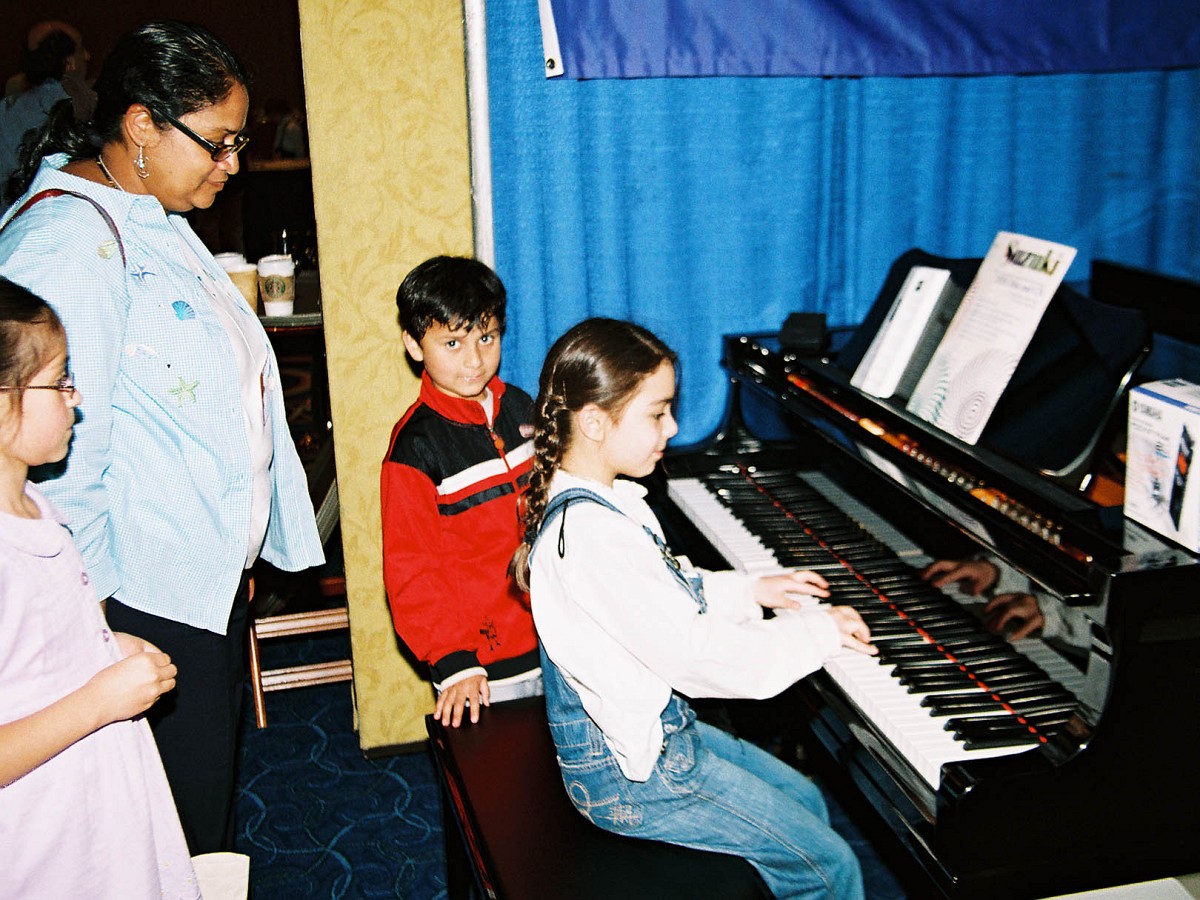 Trying out a piano in the exhibit area.