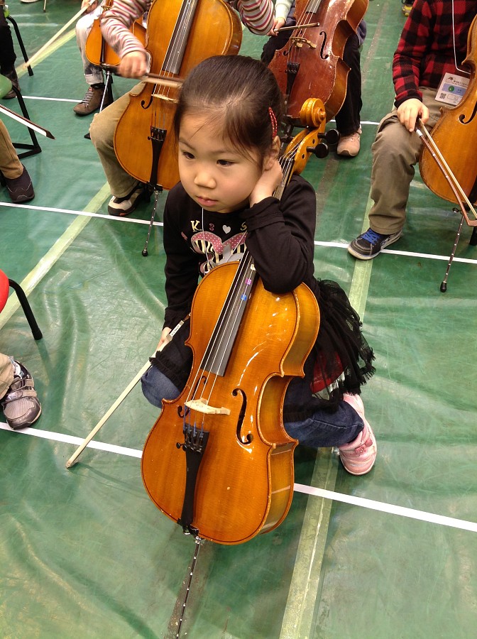 Cello student waiting to be tuned for the Opening Ceremonies