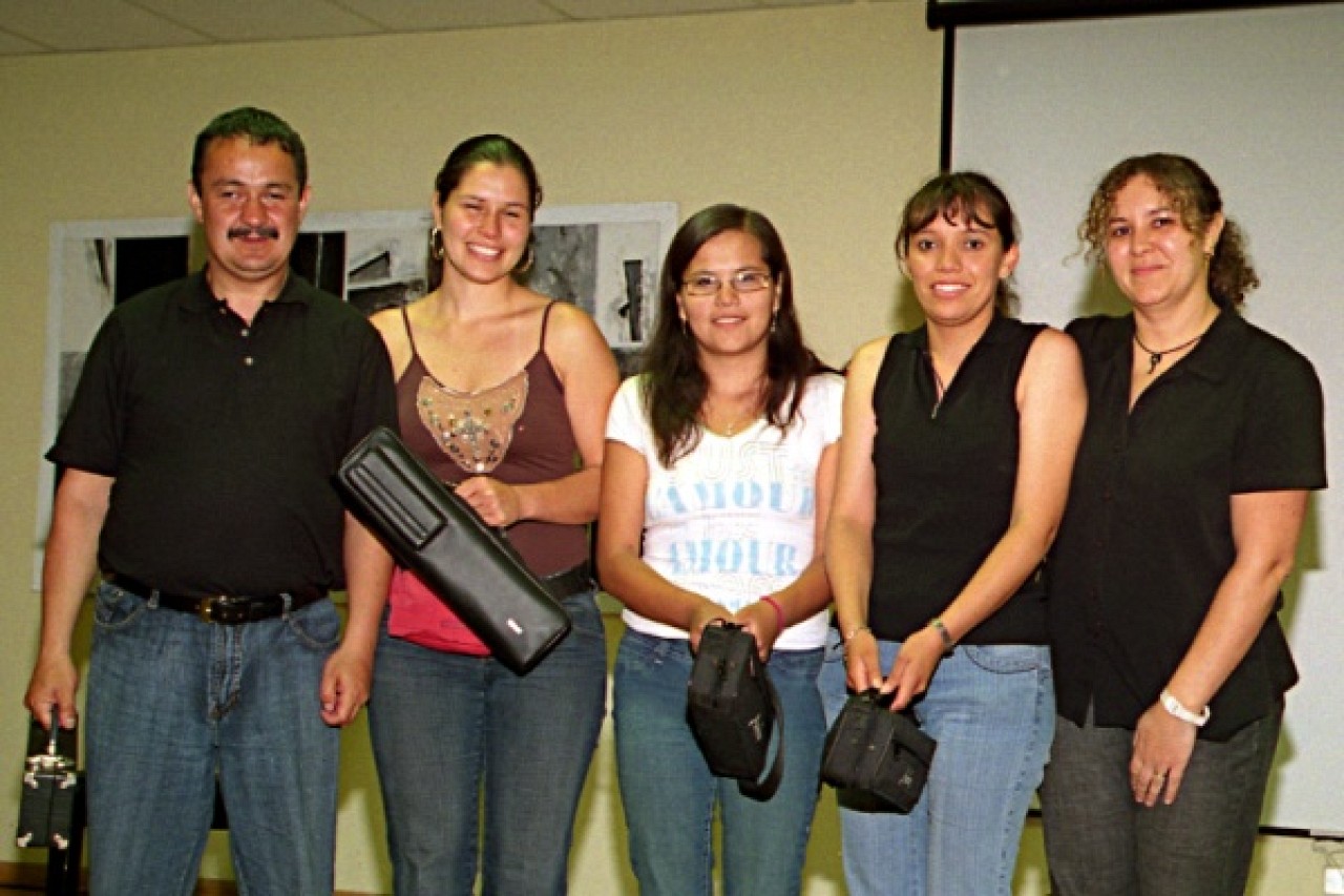 Tarcicio Andrade, Diana Bettin, Winivere Roman, and Claudia Gomez receiving donated flutes. Kelly Williamson at right.