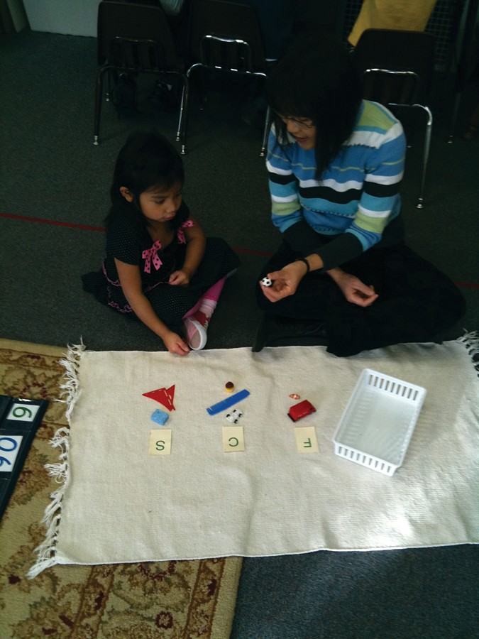 Montessori student with Wee Ling Sim, working on the sounds of the alphabet