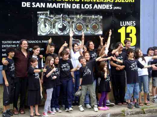 Fernando Formigo and flute group from Patagonia, Argentina in front of a billboard advertising their public concert in Asuncion, Paraguay