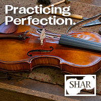 Advertisement: Violin resting on a craftsman’s table. Practicing Perfection. Shar Music.