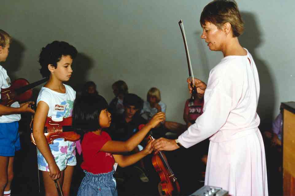 Daphne tunes violins at group class circa 1970s.