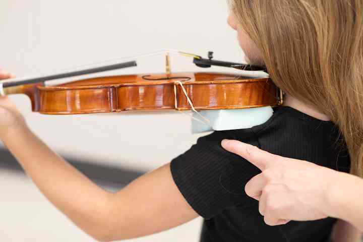 Figure 6. This violin is too large for the student. The corner of the violin extends well beyond the end of the student’s shoulder.